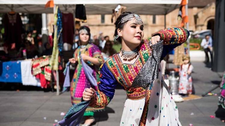 Woman dancing in a colourful traditional dress.