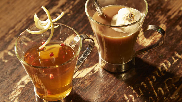 Two glass coffee cups with hot cocktails in them