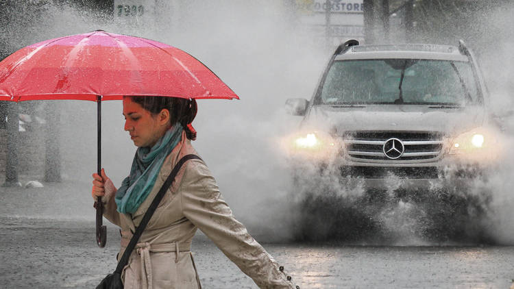 Person being splashed by car in the rain 