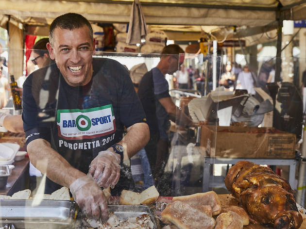 Norton Street Italian Festa Man cuts up cured meat.