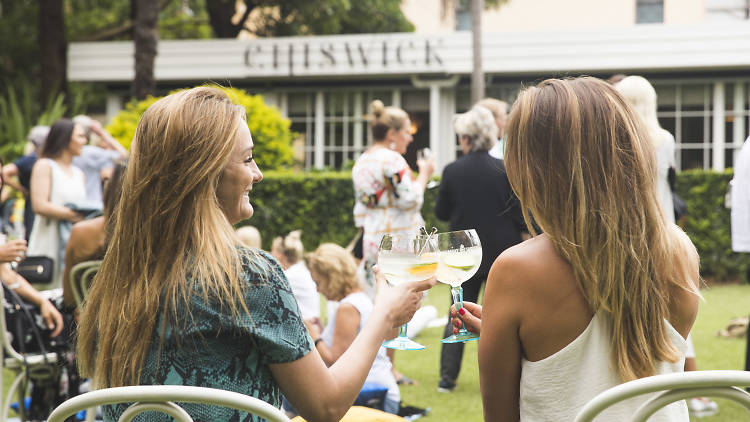 Two woman drink cocktails.