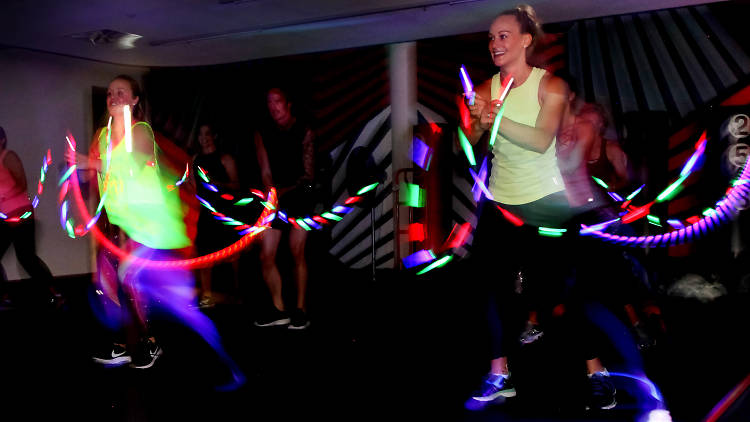 People dancing with glow sticks in the dark