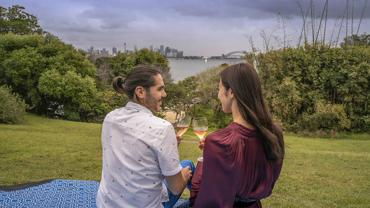 Man and woman drink Champagne overlooking the city skyline.