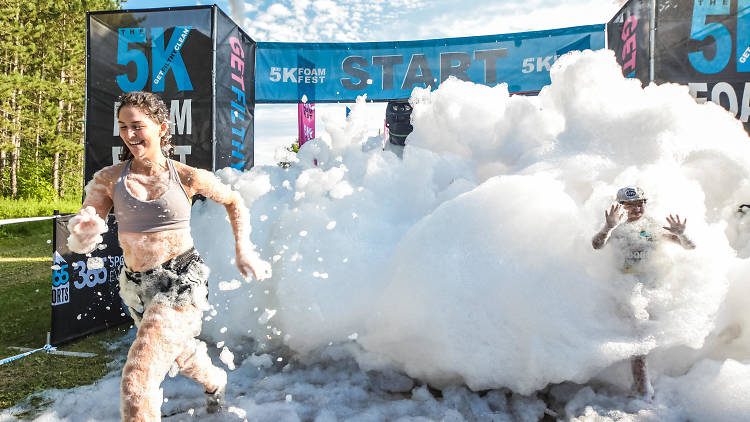 People running through a soapy foam wall.