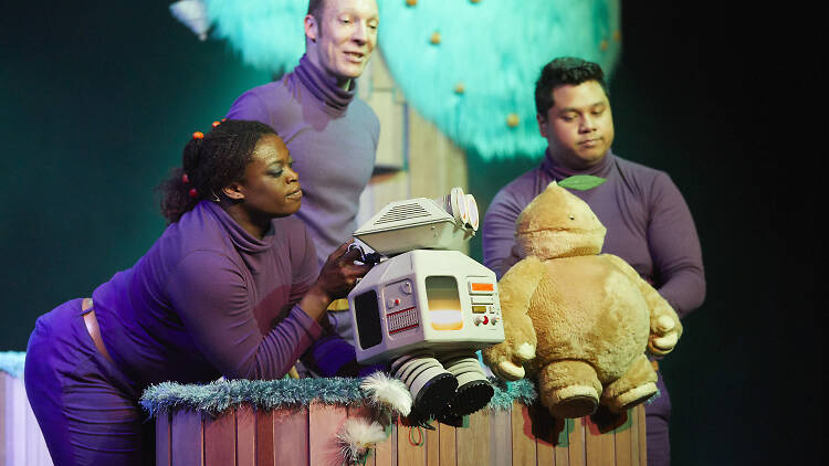 Actors and robot puppets on a stage.