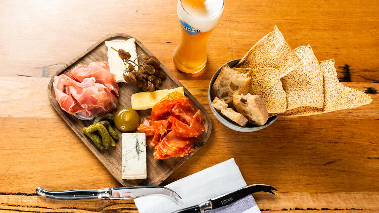 A charcuterie board and a beer