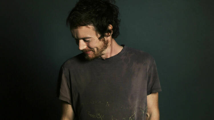 Musician Damien Rice looking down, to the right