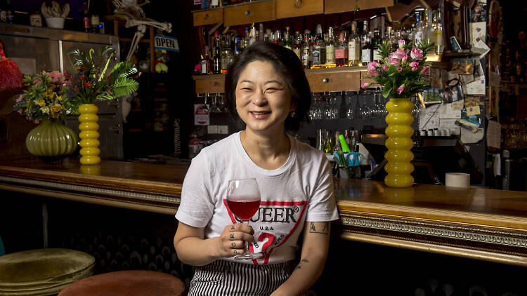 Joy Ng, owner of the Bearded Tit, sitting at the bar with a glass of wine