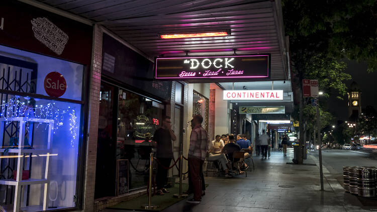 People standing outside the Dock in Redfern at night