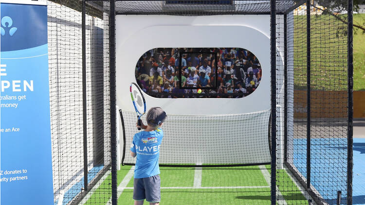 Kid playing on a mini tennis court.