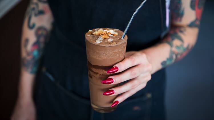 Person holding a milkshake at Matinee Coffee