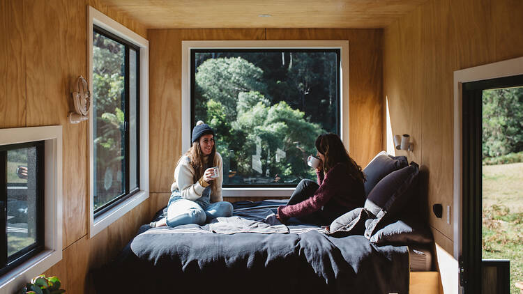 Women sitting on bed in cabin (Photograph: Luisa Brimble)
