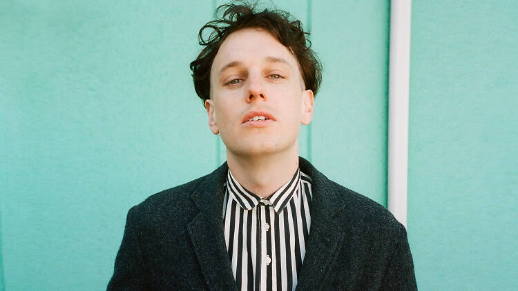 Band member from Methyl Ethel stands in front of a blue wall.