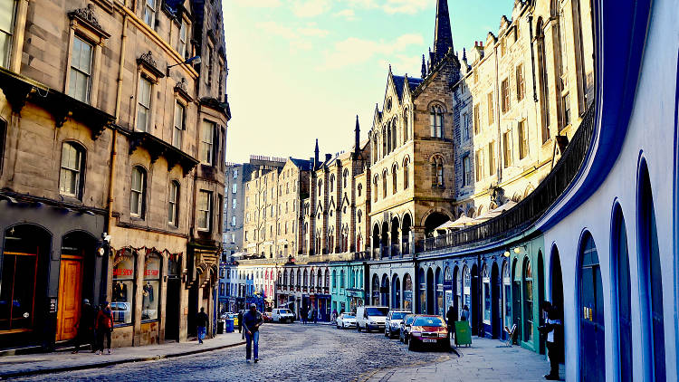 Man walking down cobbled Edinburgh street