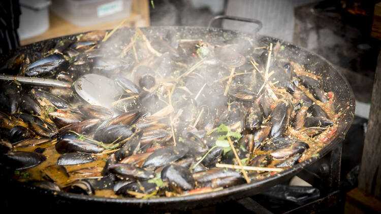 Large pan of mussels being cooked