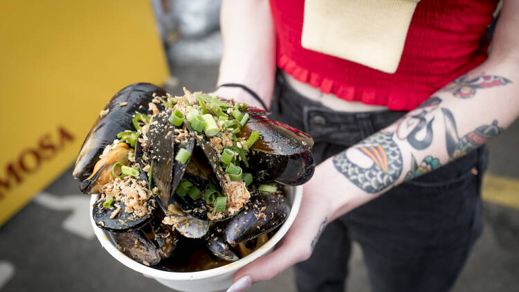 Woman holding bowl of mussels