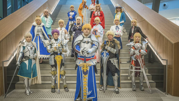 People dressed in cosplay standing on stairs.