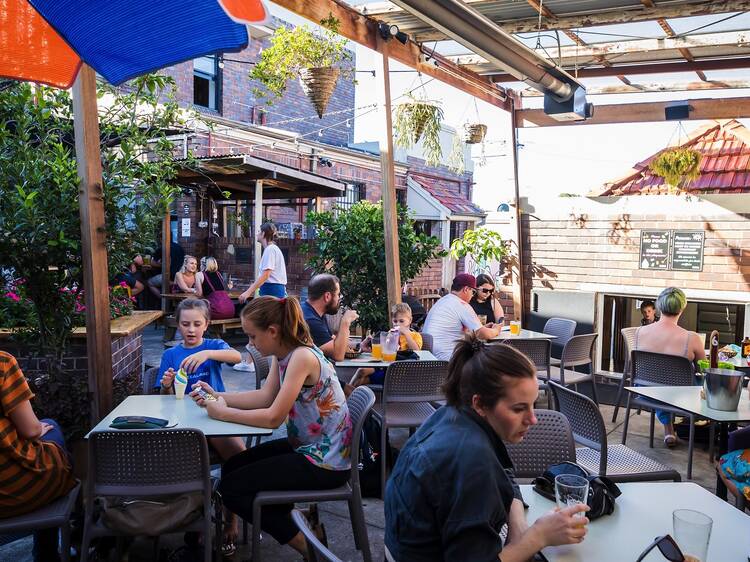 Family sitting in courtyard at The Henson Marrickville