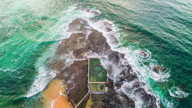 Drone shot from above looking down at Mona Vale ocean pool