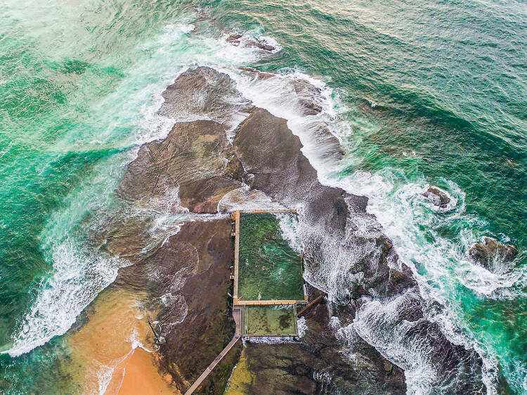 Drone shot from above looking down at Mona Vale ocean pool