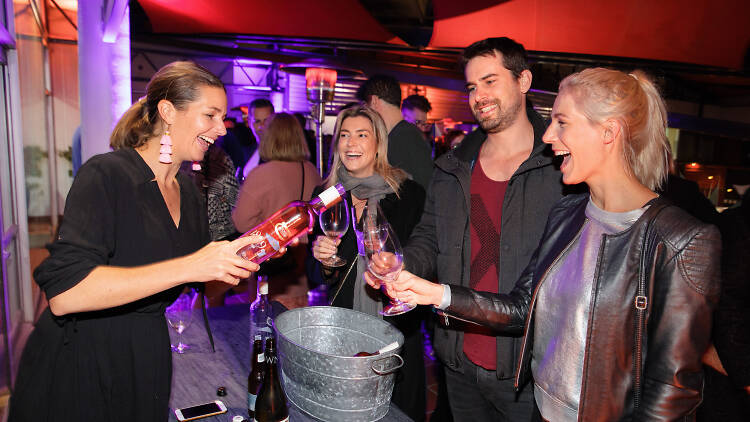 People getting poured wine by a winemaker at an event