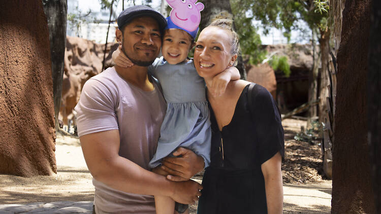 Family at the zoo with child in Peppa Pig headpiece.