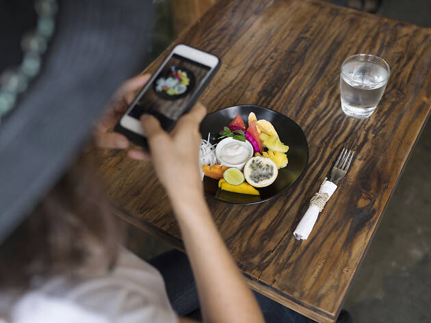 Woman taking a picture of food on a plate with smartphone