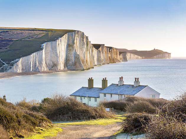 The Coast Guard Cottages & Seven Sisters Chalk Cliffs just outside Eastbourne, Sussex, England, UK The Coast Guard Cottages & Seven Sisters Chalk Cliffs just outside Eastbourne, Sussex, England, UK