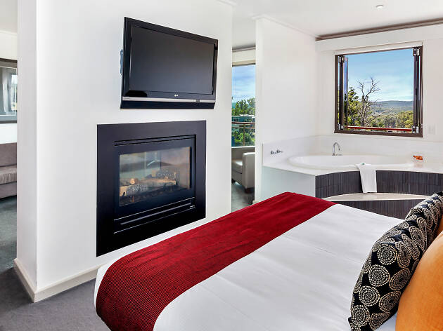 RACV Goldfields Resort Bed in hotel room with fireplace and tv at RACV Goldfields Resort