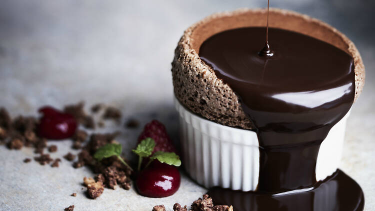 Chocolate souffle with chocolate being poured onto it