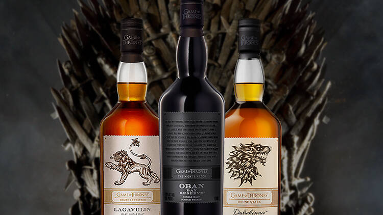 Game of Thrones whiskey bottles in front of Iron Throne