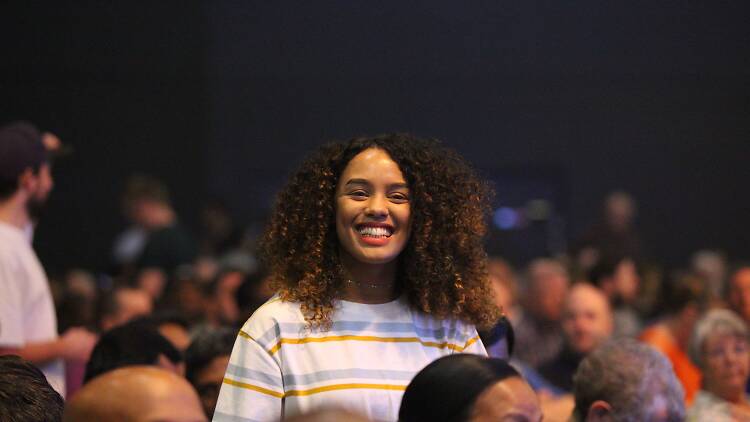 Woman smiling in a crowd.