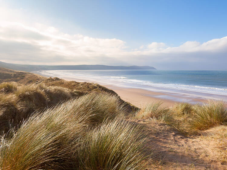 Looking west along Chesil beach from the Isle of Portland on a sunny day  with an onshore wind that has created some surf. Some anglers can be seen  fis Stock Photo 