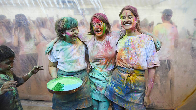 Three girls covered in coloured powder
