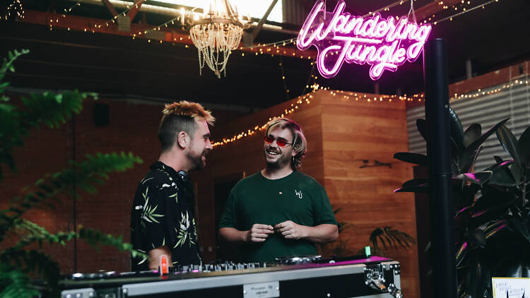 DJs smiling surrounded by plants