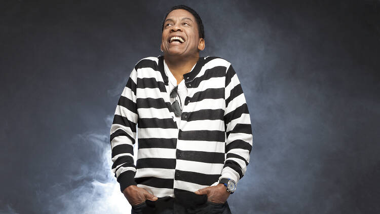 Herbie Hancock in a striped shirt laughing.
