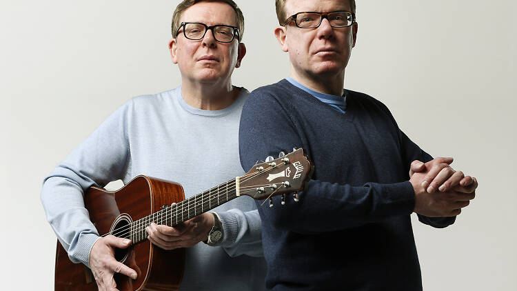 Craig and Charlie Reid posing with a guitar.