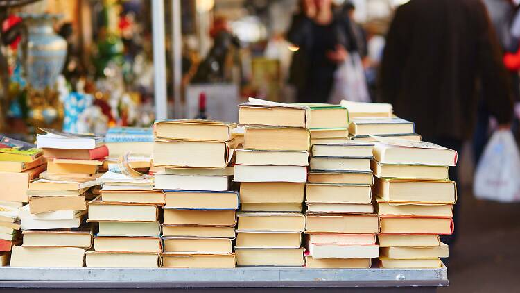 Books stacked on a table at a market.