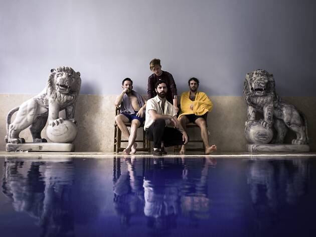 Foals band image Foals the band sat behind a pool with statues of lions either side