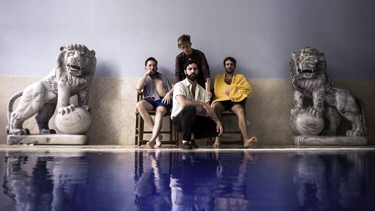Foals band image Foals the band sat behind a pool with statues of lions either side