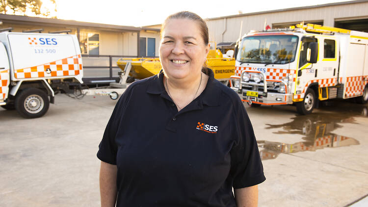 State Emergence Service volunteer Kathy Garancsi stands in front of SES trucks