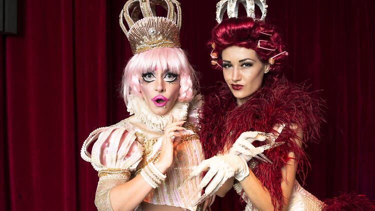 Marlena Dali and Porcelain Alice wearing crowns and pearl costumes standing in front of a red velvet curtain from the Oyster Club in Chippendale