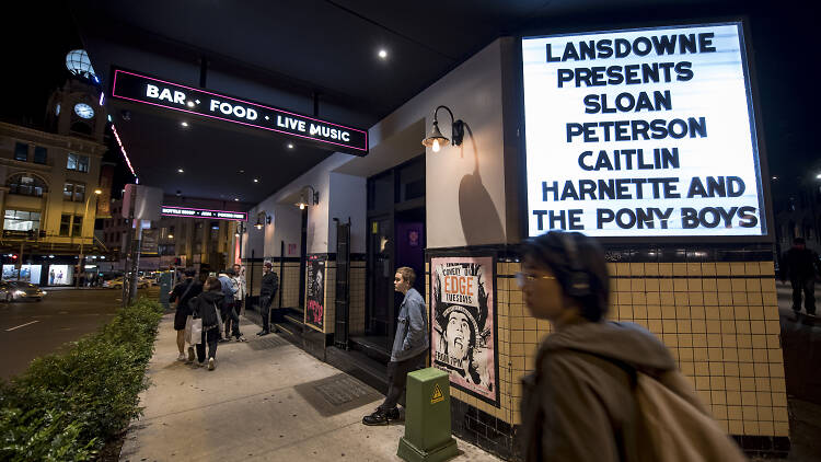 People walking next to the Lansdowne in Chippendale at night