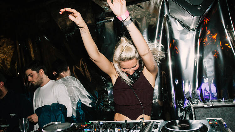 Woman dancing at a DJ booth.