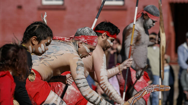 Indigenous people in traditional dress performing a dance.
