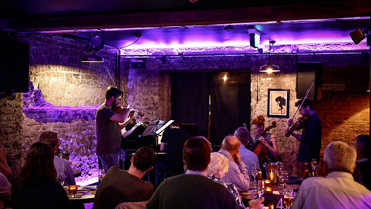 Musicians playing within the crowd at the low-lit Soultrap bar.