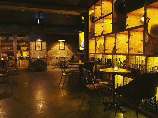 Soultrap Bar Soultrap bar's seating space and shelving in a low light.