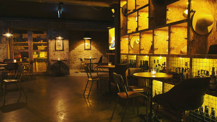 Soultrap bar's seating space and shelving in a low light.