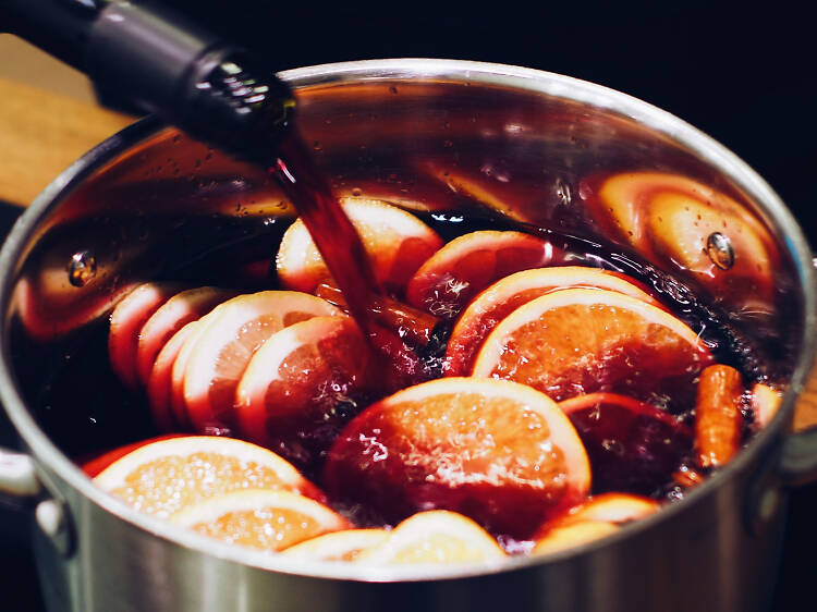 Red wine in a pot being with orange slices