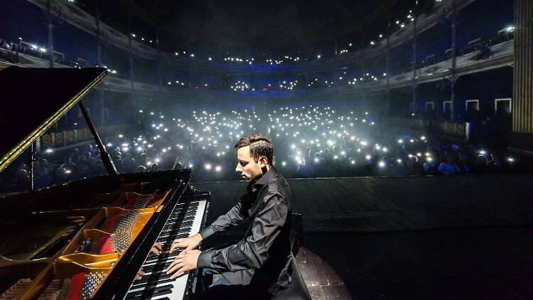 Peter Bence playing the piano to an audience with